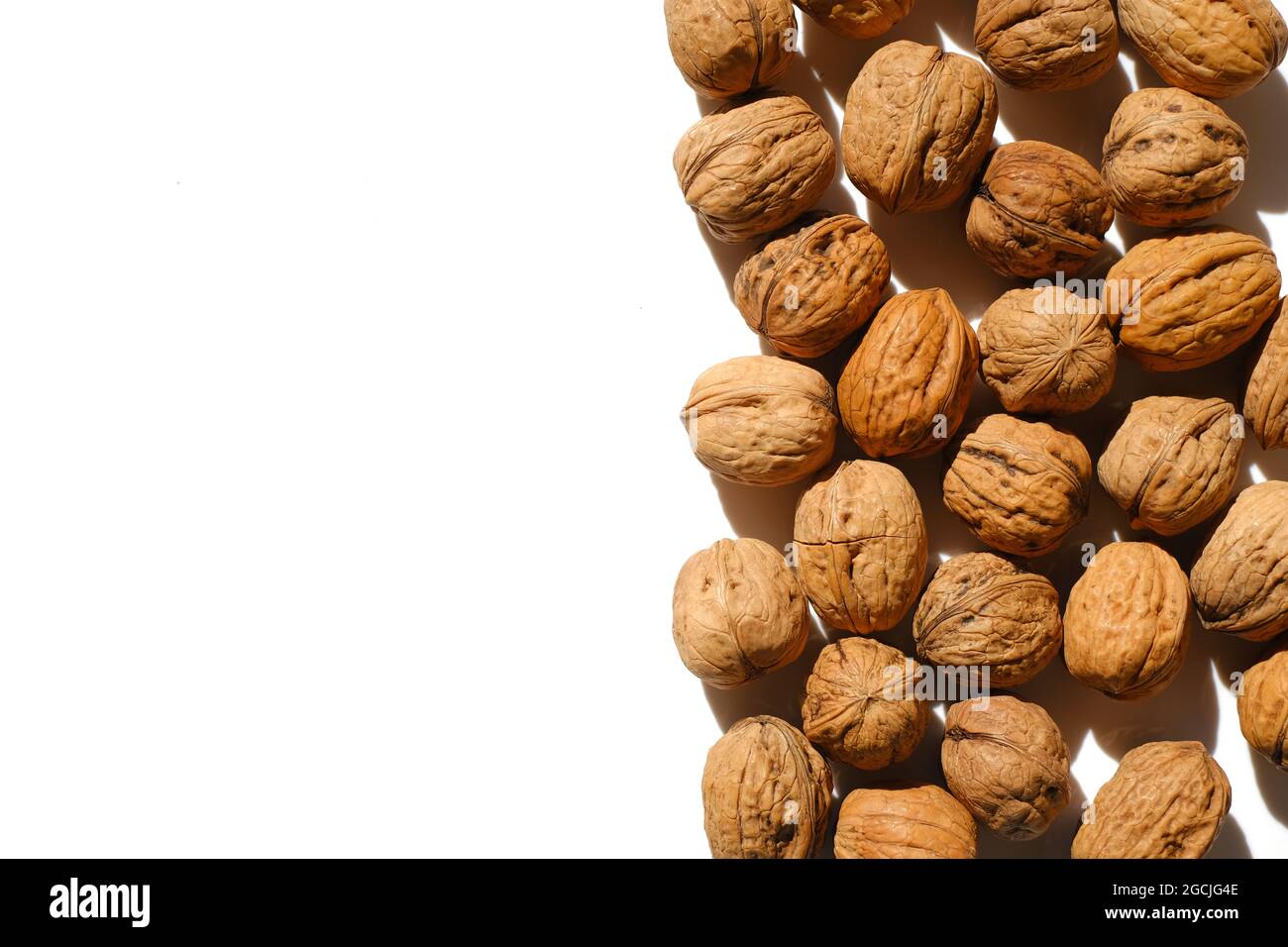 Nahaufnahme von ungeschälten Walnüssen auf hellem Hintergrund. Nüsse und Samen. Gesunde Fette. Stockfoto