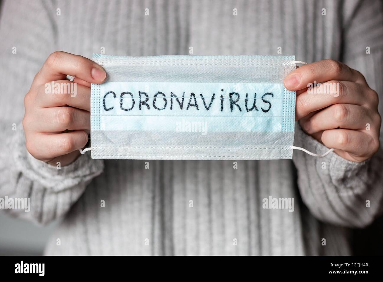 Halten einer antiviralen Maske mit der Bezeichnung Coronavirus Stockfoto