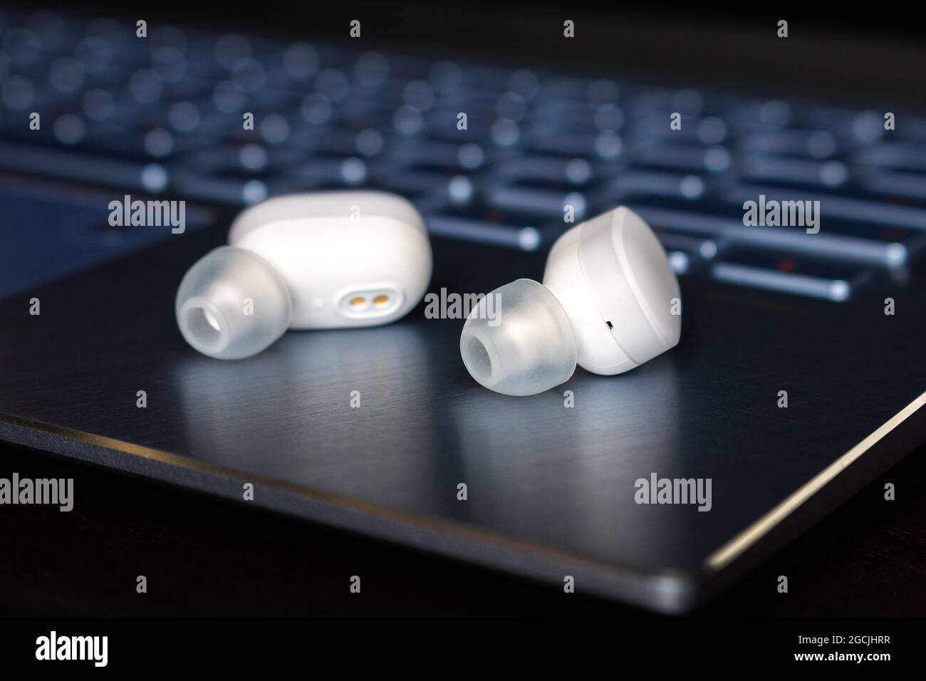 Kabellose bluetooth-Kopfhörer auf Laptop-Hintergrund Stockfoto