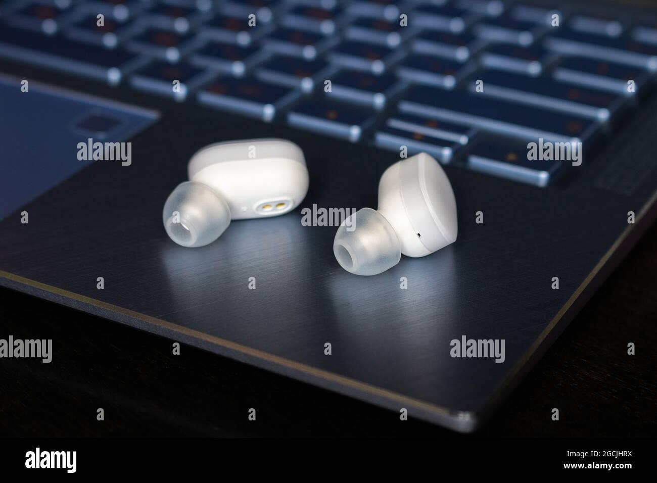 Weiße kabellose bluetooth-Kopfhörer in Nahaufnahme des Laptops Stockfoto