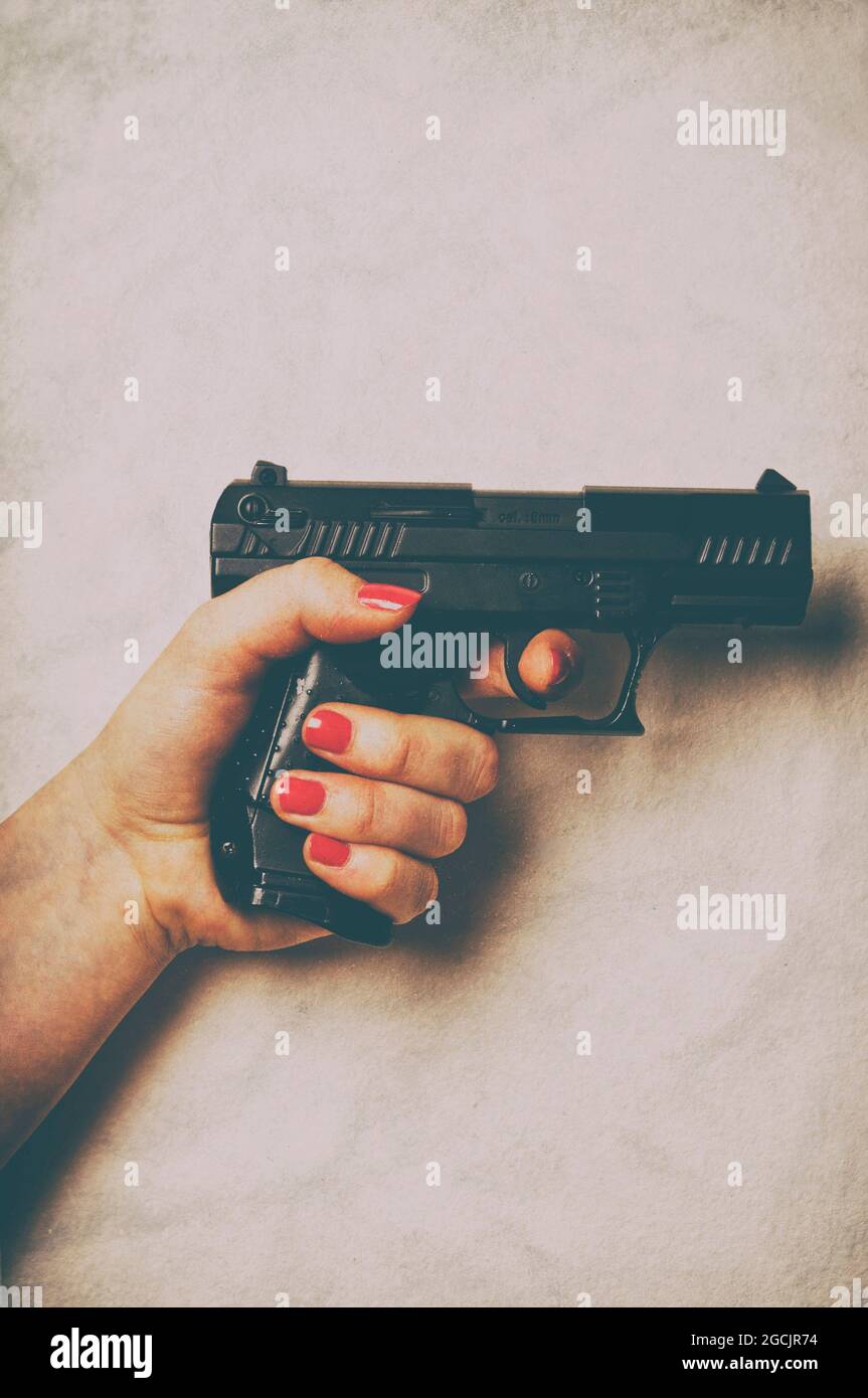 Frau hält eine Waffe in der Hand Stockfoto