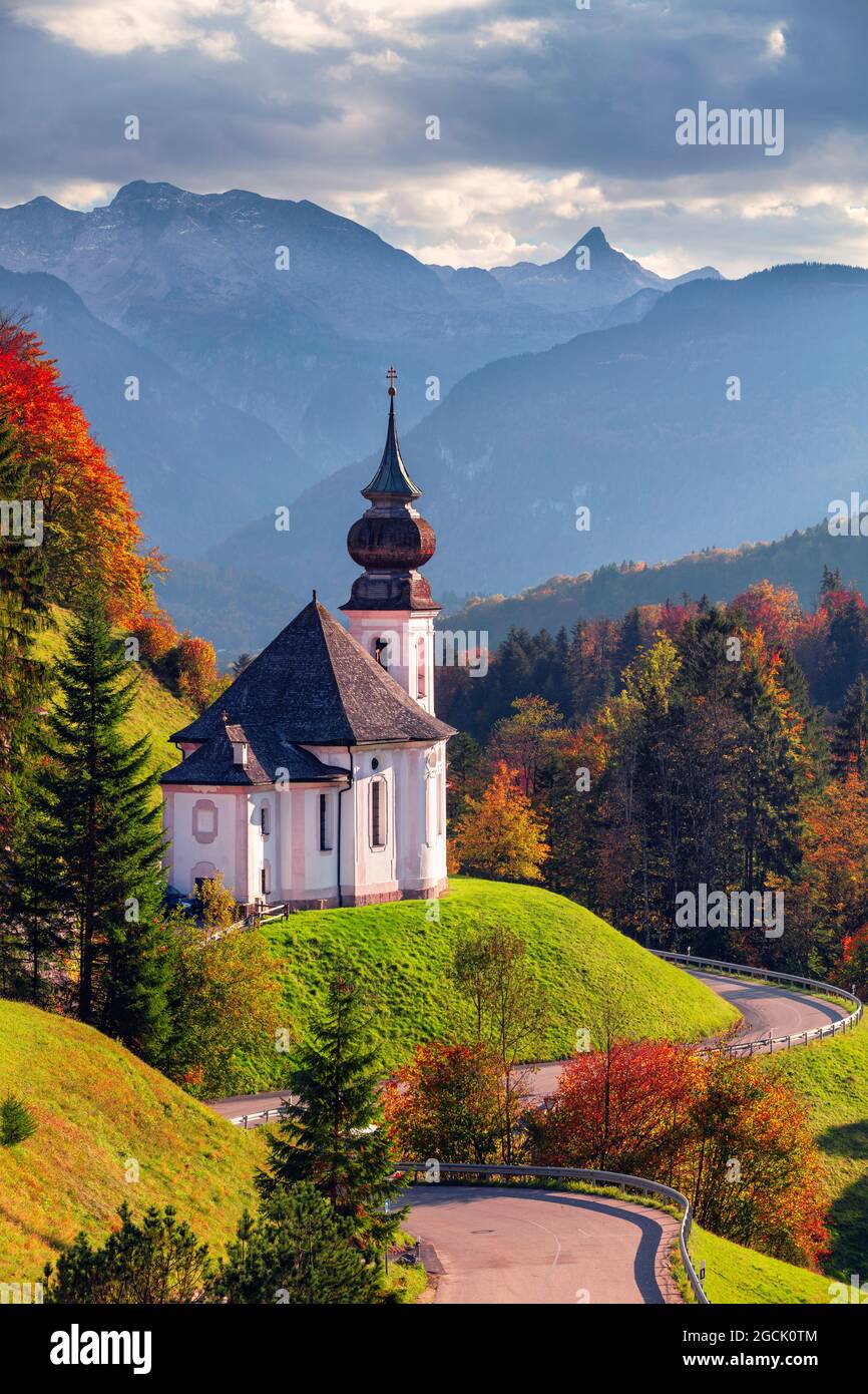 Herbst in den bayerischen Alpen. Landschaftsbild der Bayerischen Alpen mit Maria-Gern-Kirche und Watzmann-Berg bei schönem Herbstuntergang. Stockfoto