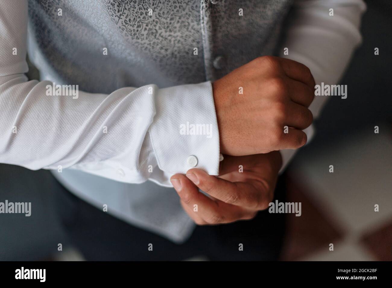 Hoher Crop unkenntlich Bräutigam in eleganten stilvollen Weste Knopfmanschette auf weißem Hemd Stockfoto