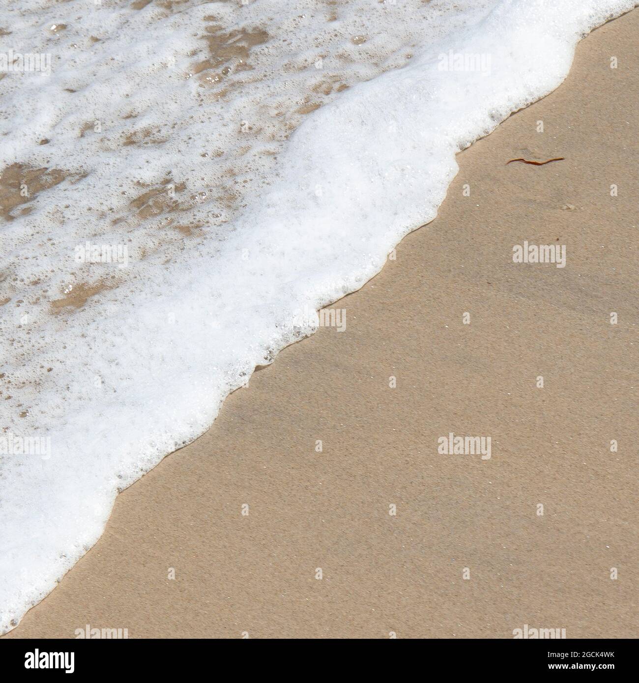 Welle des Atlantischen Ozeans, Salzwasser und Strandsand Spalten sich diagonal, quadratisches Bild Stockfoto