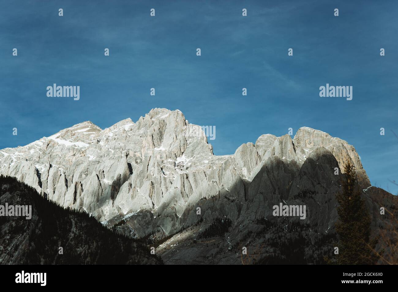Niedriger Winkel der rauen Bergkette am blauen Himmel in der Nähe der Crescent Falls in Alberta, Kanada Stockfoto