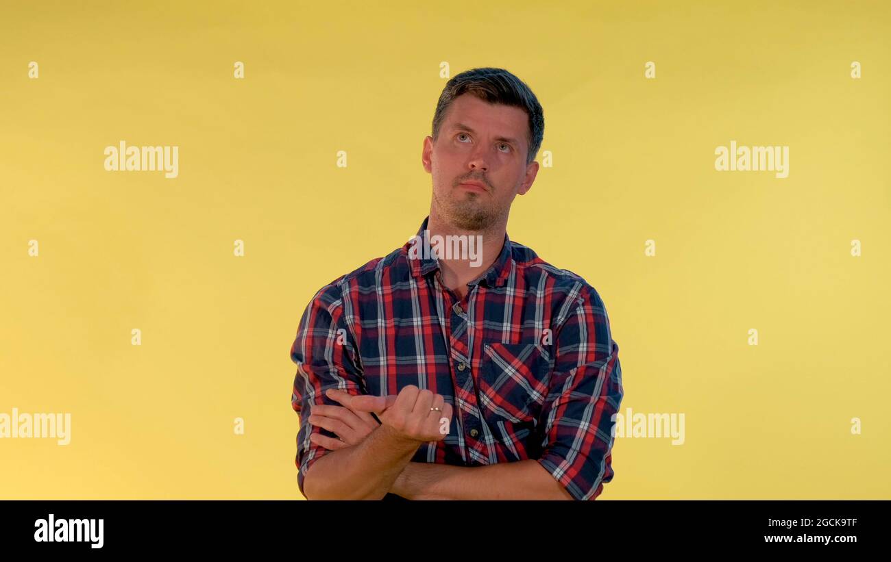Gutaussehender Mann, der etwas auf die Finger zählt. Nahaufnahme auf gelbem Hintergrund. Stockfoto
