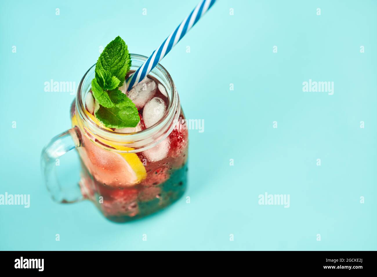 Kalter erfrischender Cocktail mit Eis, Minze und Kopierfläche auf blauem Hintergrund. Party, Sommer, Relax-Konzept Stockfoto