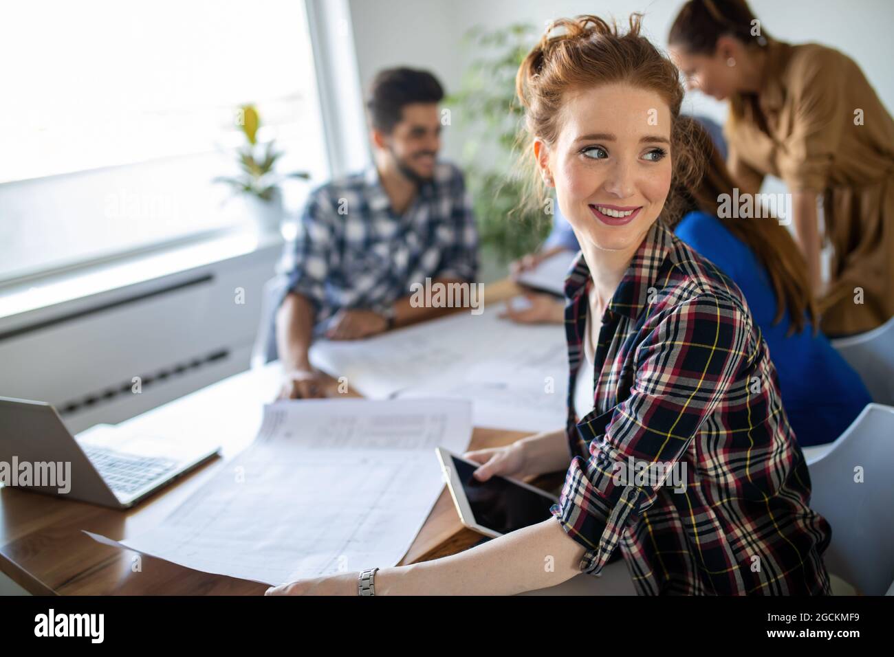 Glückliche, multiethnische Gruppe von Geschäftsleuten, die gemeinsam an einem Treffen im Büro arbeiten Stockfoto
