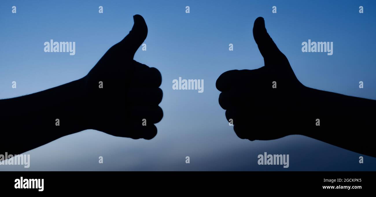 Zwei männliche Hände zeigen Daumen nach oben Zeichen. Stimme Zu. Akzeptieren. Wie Geste Silhouette. Erfolg. Stockfoto