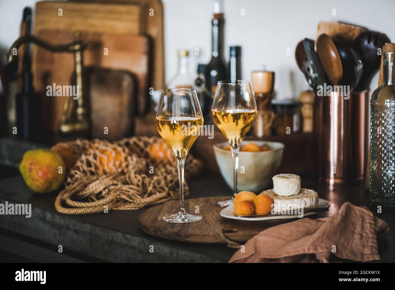 Orangen- oder Amberwein in Gläsern über der Küchentheke Stockfoto