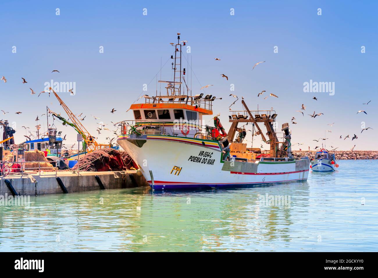 Poema do mar ein großer Fischertrawler dockte im Hafen von Quarteira an, umgeben von Möwen, Quarteira Algarve Portugal Stockfoto