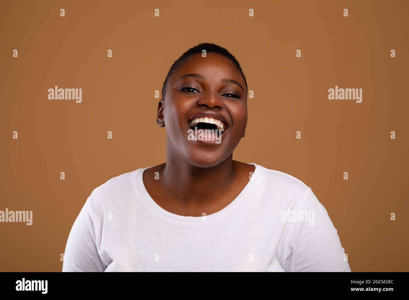 Porträt einer jungen molligen schwarzen Frau, die lachend ist Stockfoto