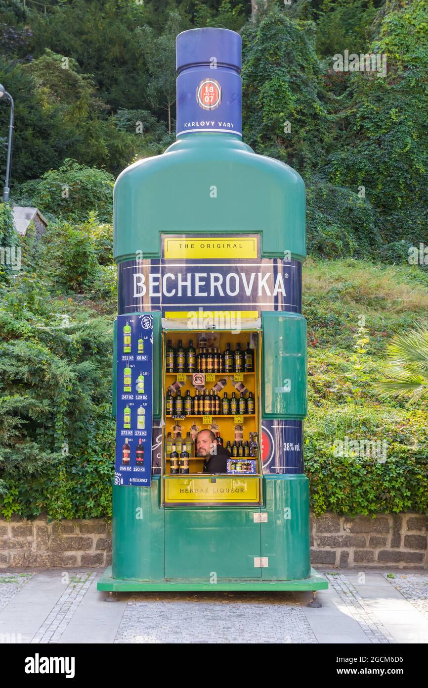 Mann, der in Karlovy Vary, Tschechien, Getränke in einer großen Becherovka-Flasche verkauft Stockfoto
