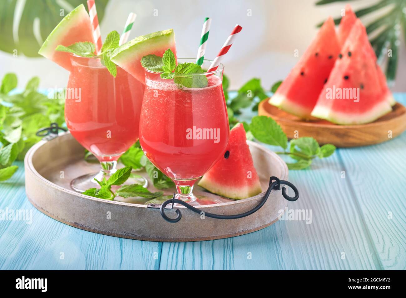 Wassermelone-Cocktail mit Minze und Eis. Sommerliche Erfrischungsgetränke in Gläsern auf blauem Holztisch. Konzept der gesunden Sommer essen. Stockfoto