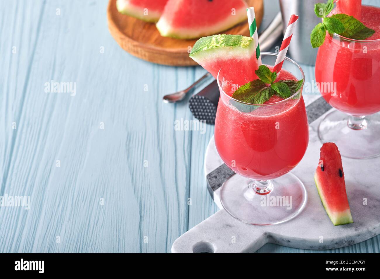 Wassermelone-Cocktail mit Minze und Eis. Sommerliche Erfrischungsgetränke in Gläsern auf blauem Holztisch. Konzept der gesunden Sommer essen. Stockfoto