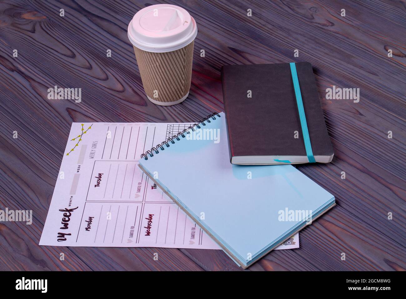 Notizblock und Klendar auf dem Holzschreibtisch. Stockfoto