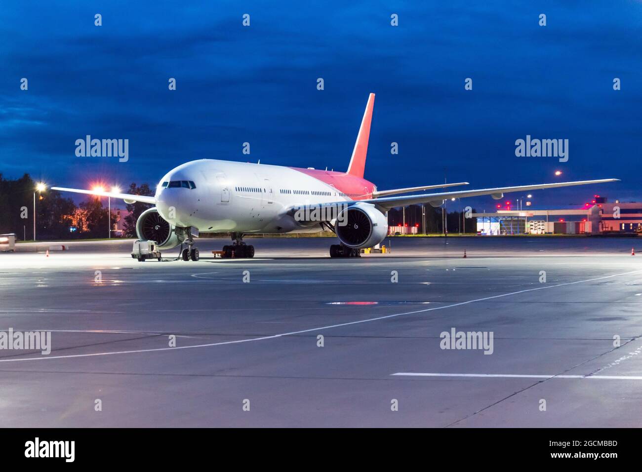 Nachtansicht des Flughafens und ein großes Passagierflugzeug auf dem Parkplatz vor dem Flug Stockfoto