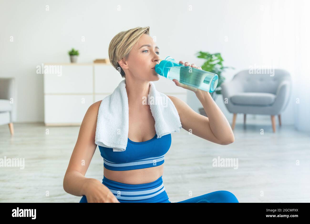 Sportliche Frau in blauer Sportswear Trinkwasser Stockfoto