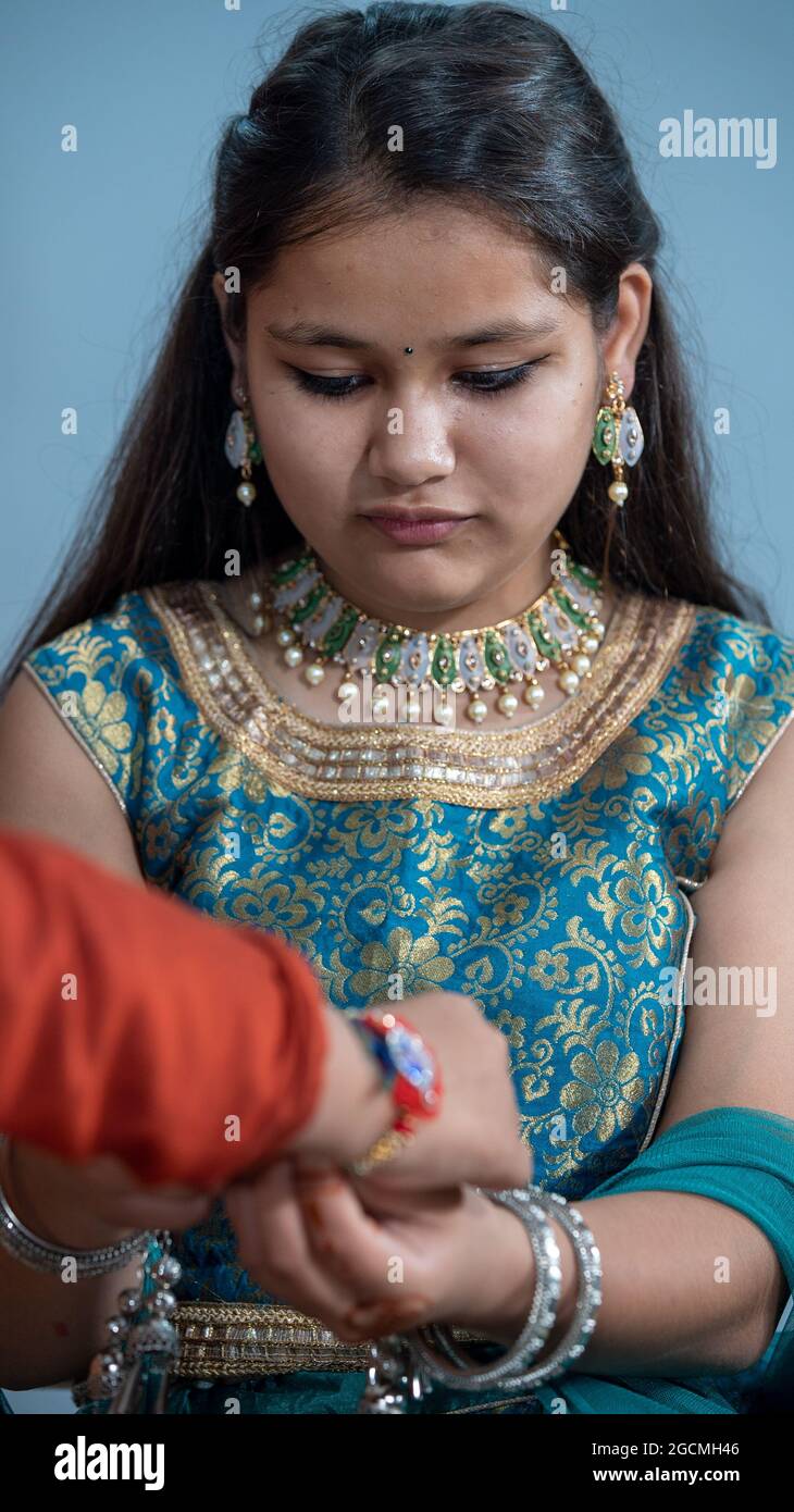Schwester, die Raksha Bandhan während des Festivals oder der Zeremonie an das Handgelenk des Bruders bindet - Raksha Bandhan feierte in ganz Indien als selbstlose Liebe oder Beziehung zwischen Bruder und Schwester Stockfoto