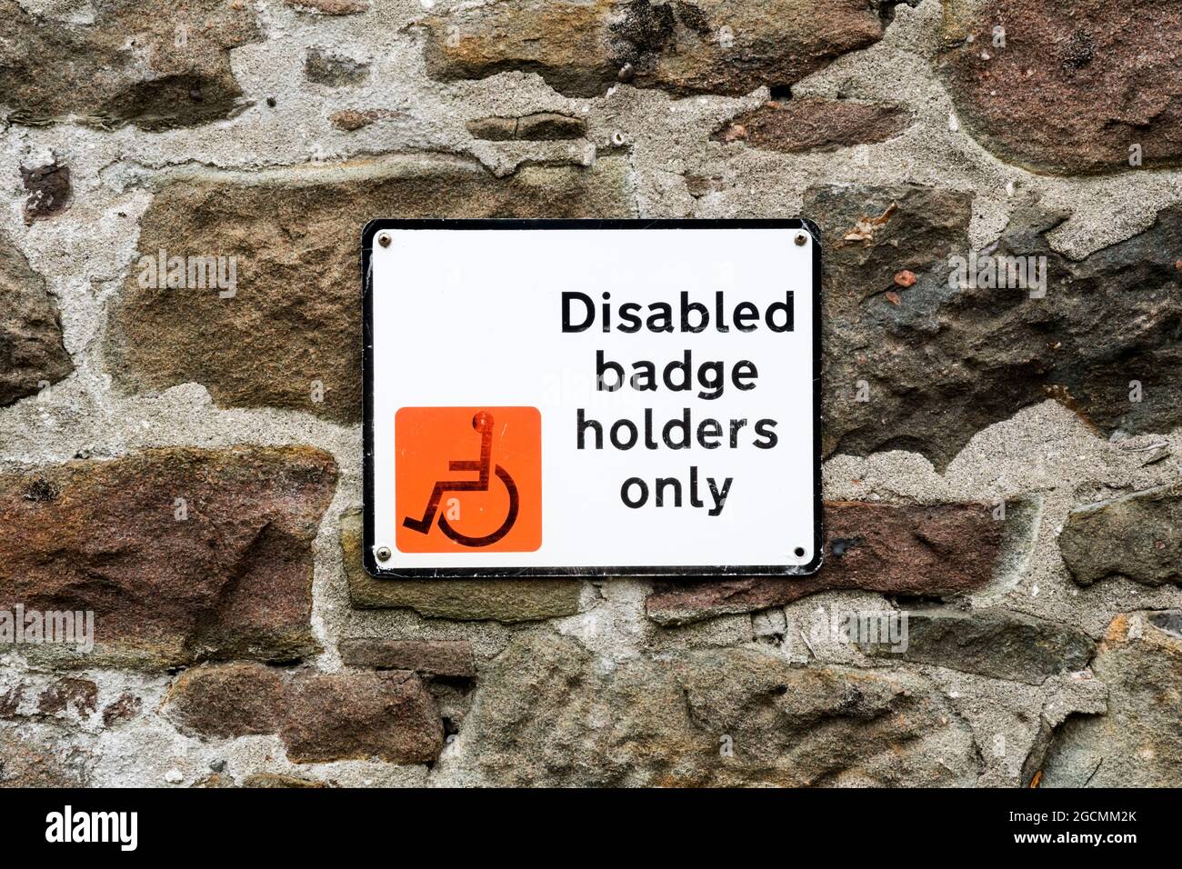 Behindertenausweis Inhaber nur Parkplatz Schild an einer rauen Steinwand. Stockfoto