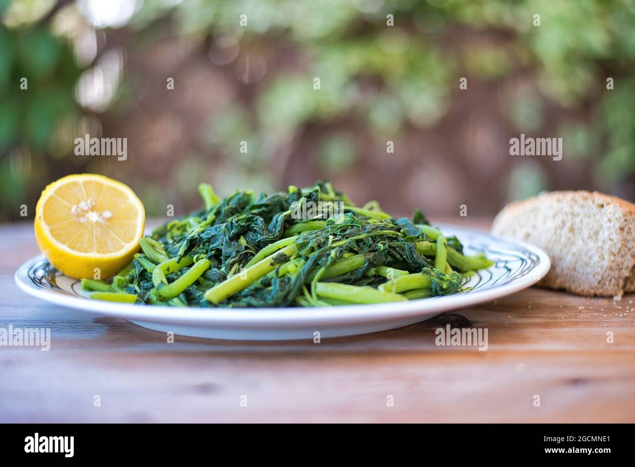 Amaranthus blitum . Vlita Salat auf einem Teller, auf einem alten Holztisch Stockfoto