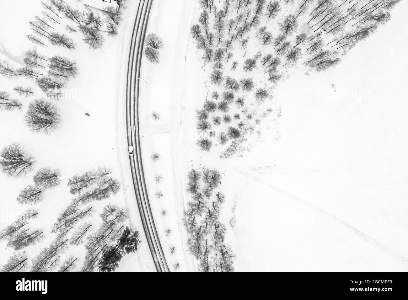Luftaufnahme eines Autos, das durch einen verschneiten Wald in Rovaniemi, Lappland, Finnland fährt Stockfoto