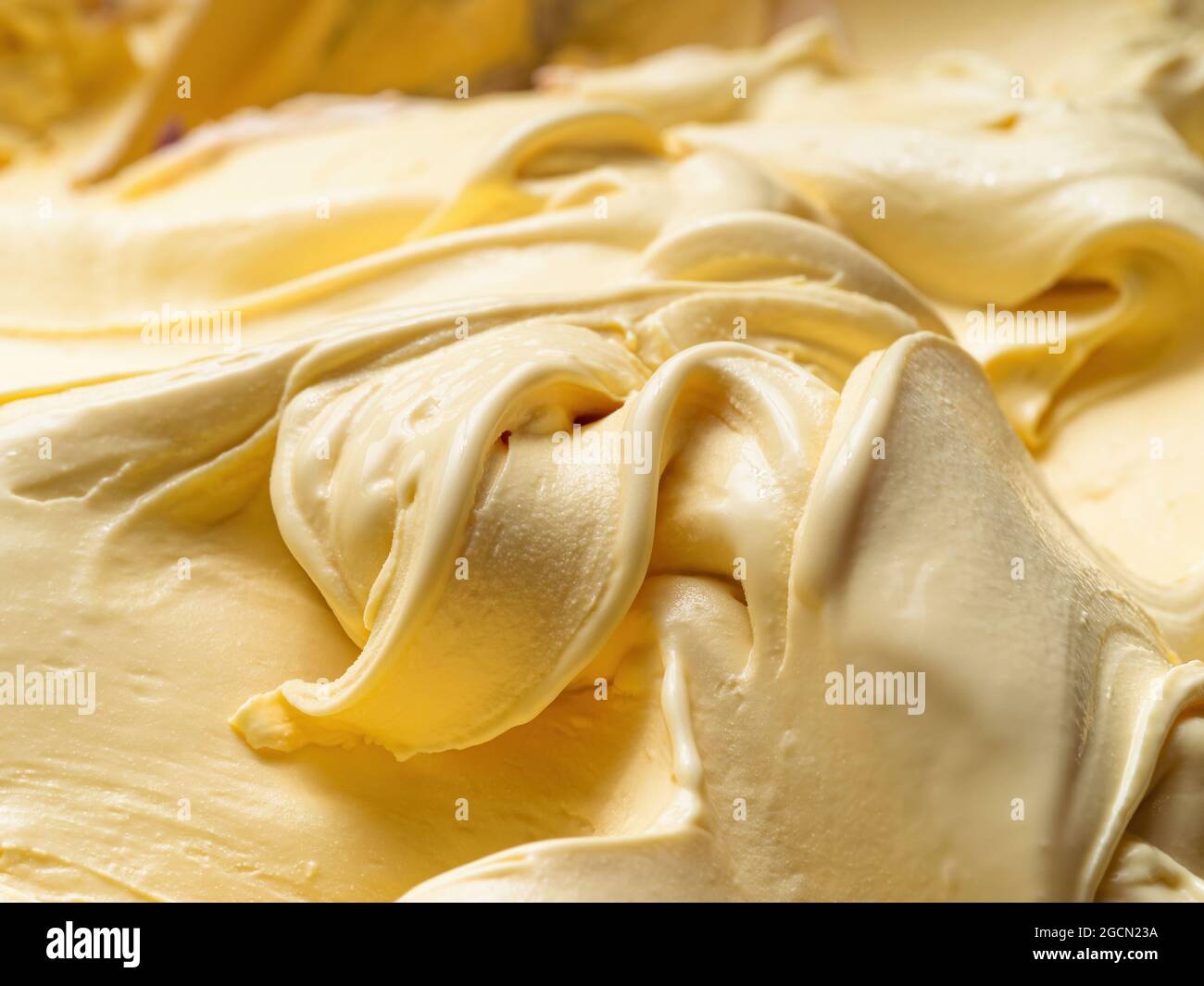 Gelato mit Vanila-Geschmack – Vollformat. Nahaufnahme einer beigen Oberflächenstruktur von Vanilleeis. Stockfoto