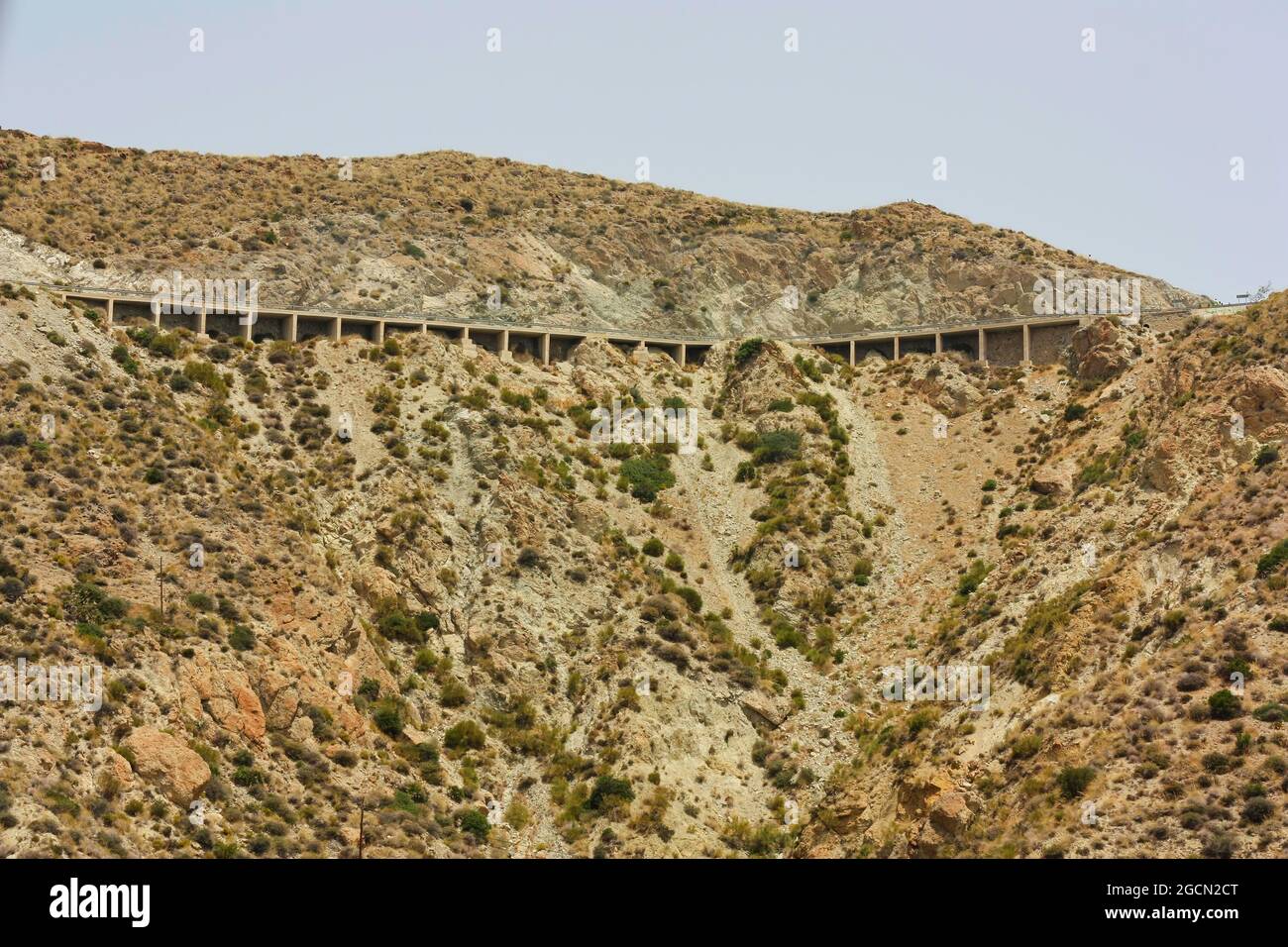 Blick auf Carboneras aus der bergigen Landschaft, kurvige Straße und großes Viadukt. Naturpark Cabo de Gata, Provinz Almería, Spanien. Stockfoto