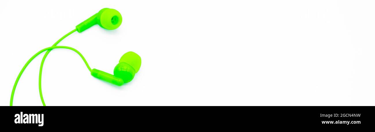 Banner mit grünen EarPods Basic in-Ear Headphone Earbuds auf weißem Hintergrund, sieht aus wie eine Umarmung. Speicherplatz kopieren. Stockfoto