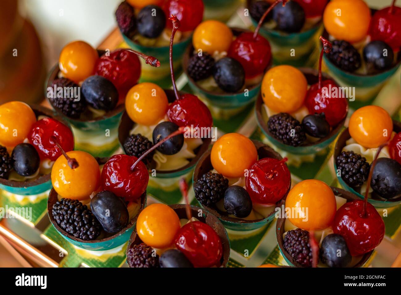 Vier verschiedene Früchte, in kleinen Schüsseln auf einem für eine Party dekorierten Buffettisch angeordnet. Stockfoto