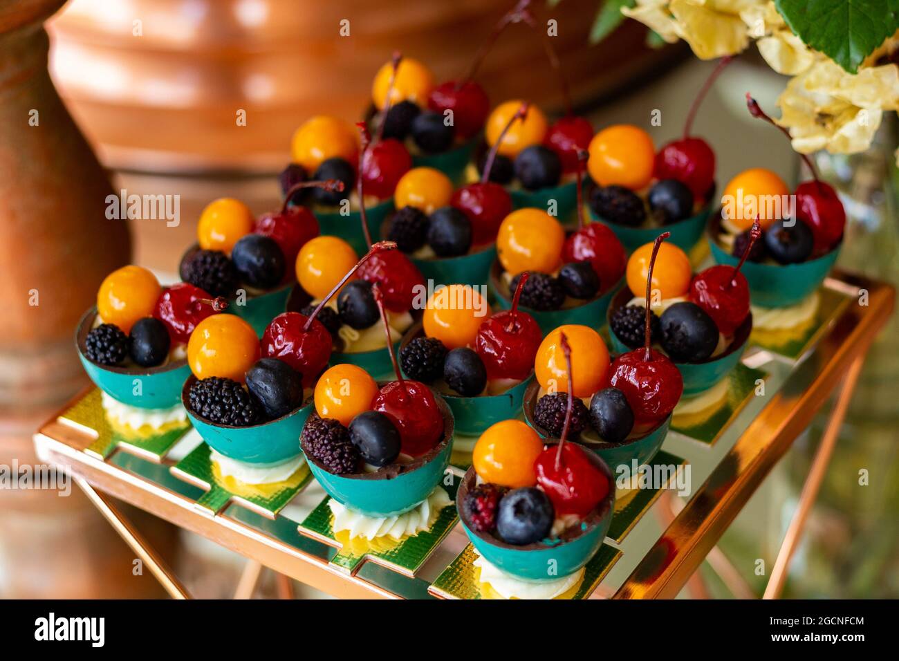 Vier verschiedene Früchte, in kleinen Schüsseln auf einem für eine Party dekorierten Buffettisch angeordnet. Stockfoto