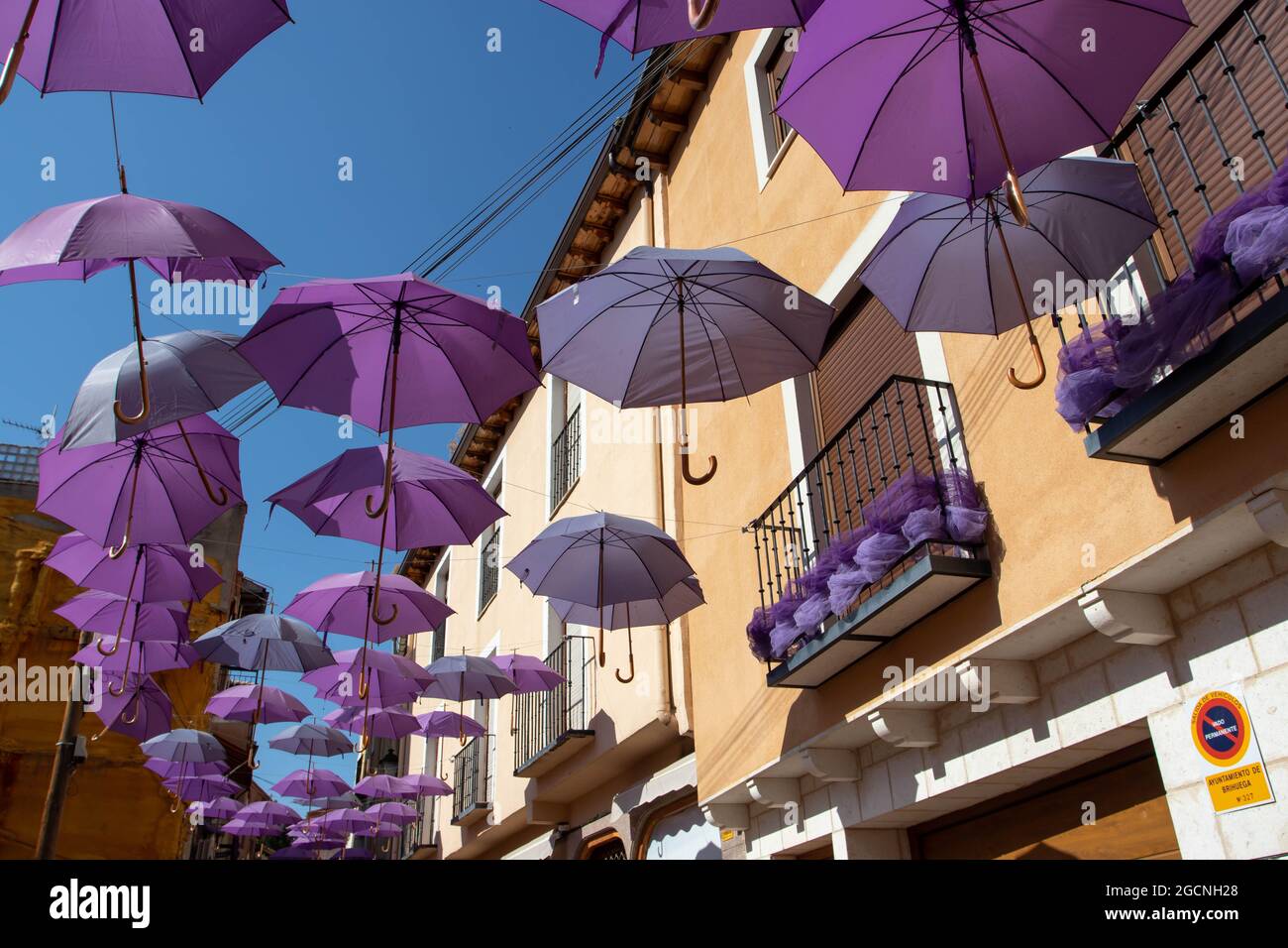 BRIHUEGA, SPANIEN - 10. JULI 2021: Violette Regenschirme und Dekoration auf der Straße während der Blütezeit der Lavendelfelder, Brihuega, Guadalajara, Castilla-La M Stockfoto