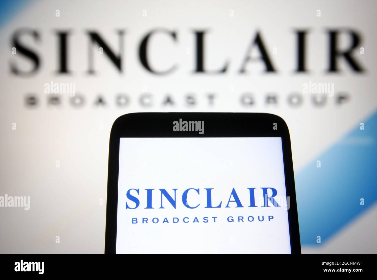 In dieser Abbildung ist ein Logo der Sinclair Broadcast Group (SBG) auf einem Smartphone und einem pc-Bildschirm zu sehen. Stockfoto