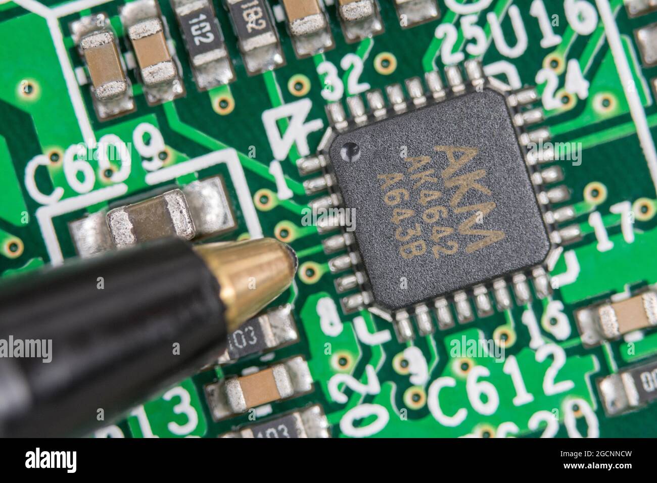 32-poliger AKM IC-Chip auf älterer Leiterplatte/leiterplatte. Es wird angenommen, dass es sich um einen Audio-Codec-Chip geht. Konzentrieren Sie sich auf die linke Hälfte des Chips. Skala von der Spitze des Kugelschreibers Stockfoto