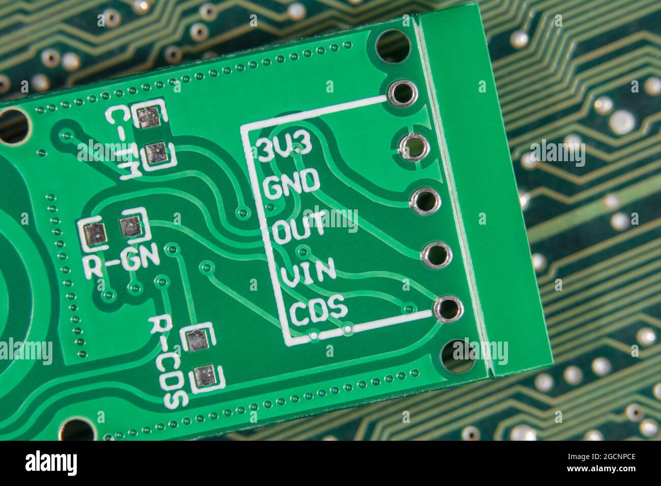 Makroaufnahme der Eingangsbohrungen der leiterplatte für kleine Leiterplatten. Rückseite eines Motion-Sensing-Moduls mit 3 Volt, Masse und anderen pcb-Pinbelegungen. Stockfoto