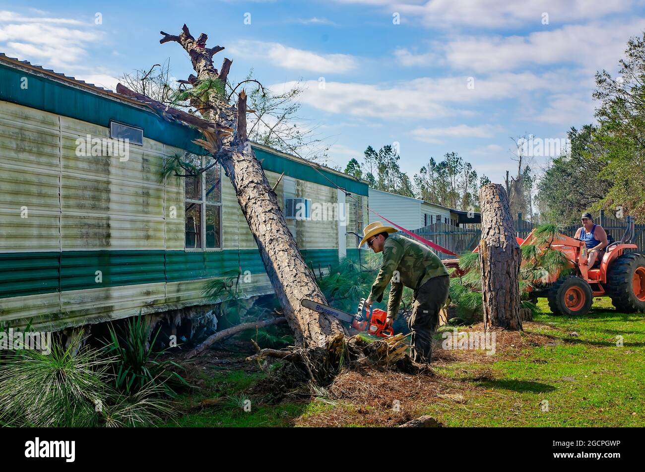 Männer räumen Bäume von einem Mobilheim im Twin Oaks Mobile Home Park nach dem Orkil Michael, 18. Oktober 2018, in Marianna, Florida. Stockfoto