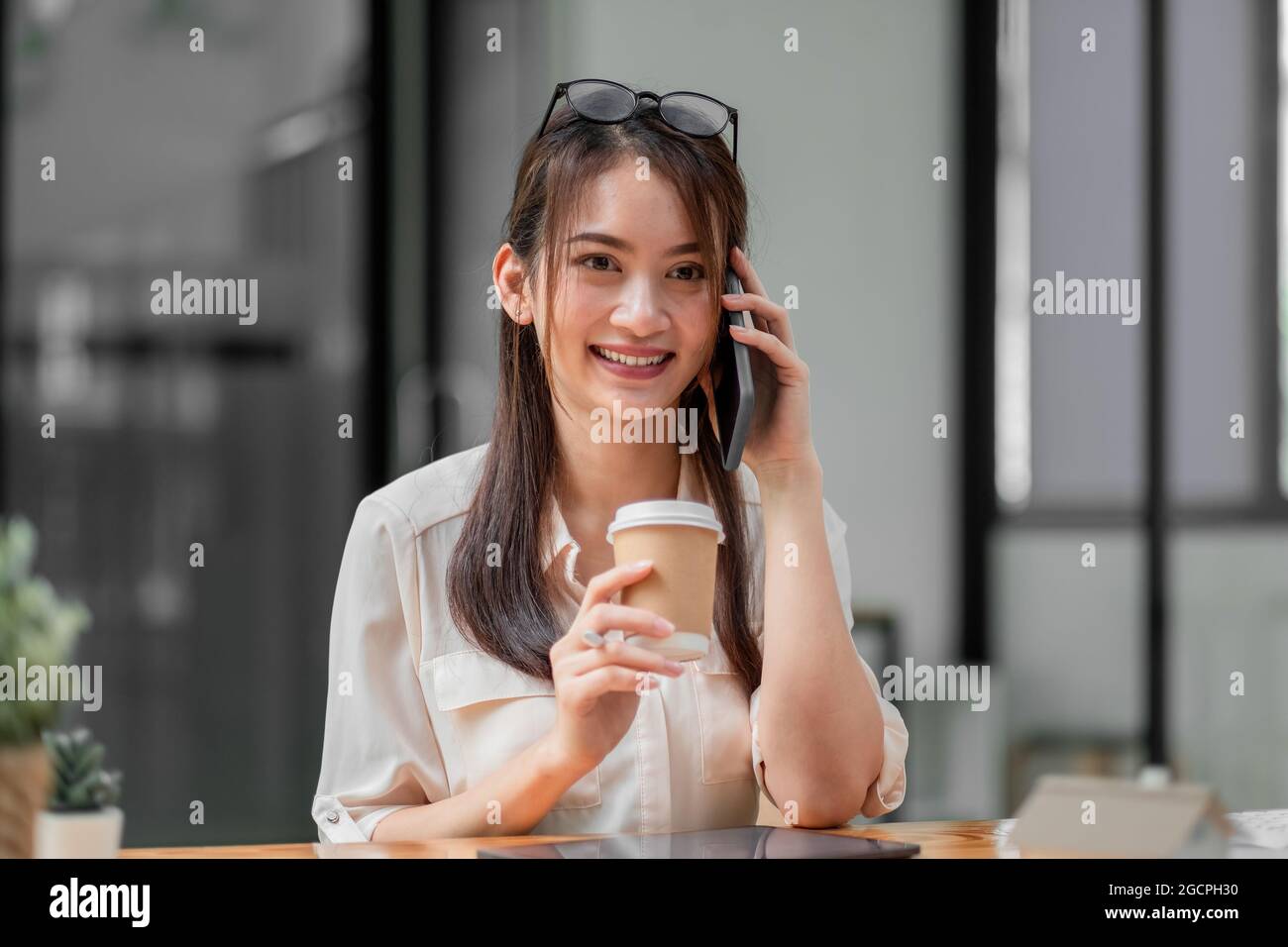 Porträt der jungen asiatischen Geschäftsfrau schöne charmante lächeln und sprechen auf dem Handy im Büro Stockfoto