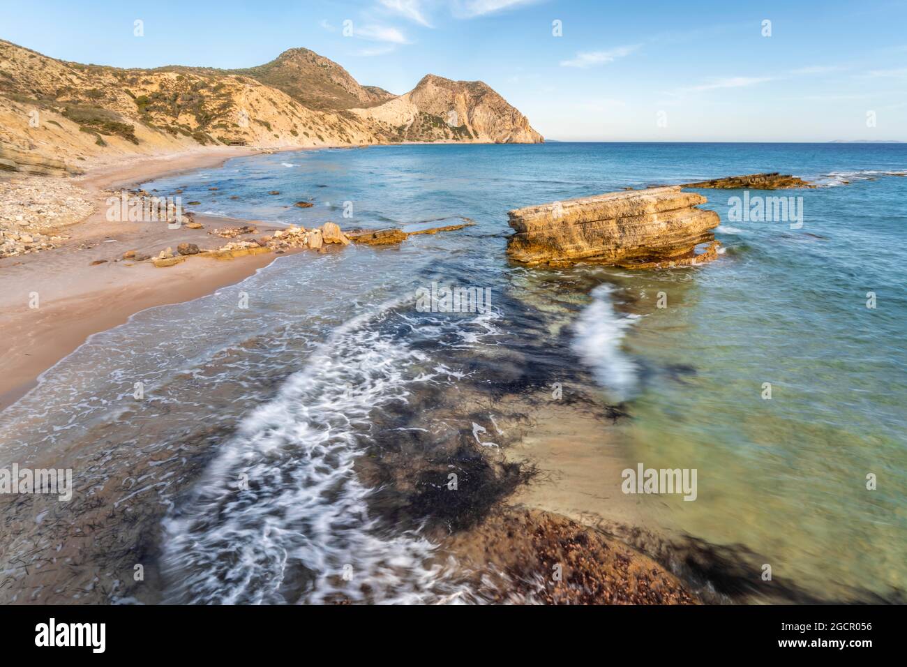 Felsen im Wasser, Wellen, die gegen Felsen krachen, Sandstrand mit felsigen Klippen, Paralia Paradisos, Kos, Dodekanes, Griechenland Stockfoto