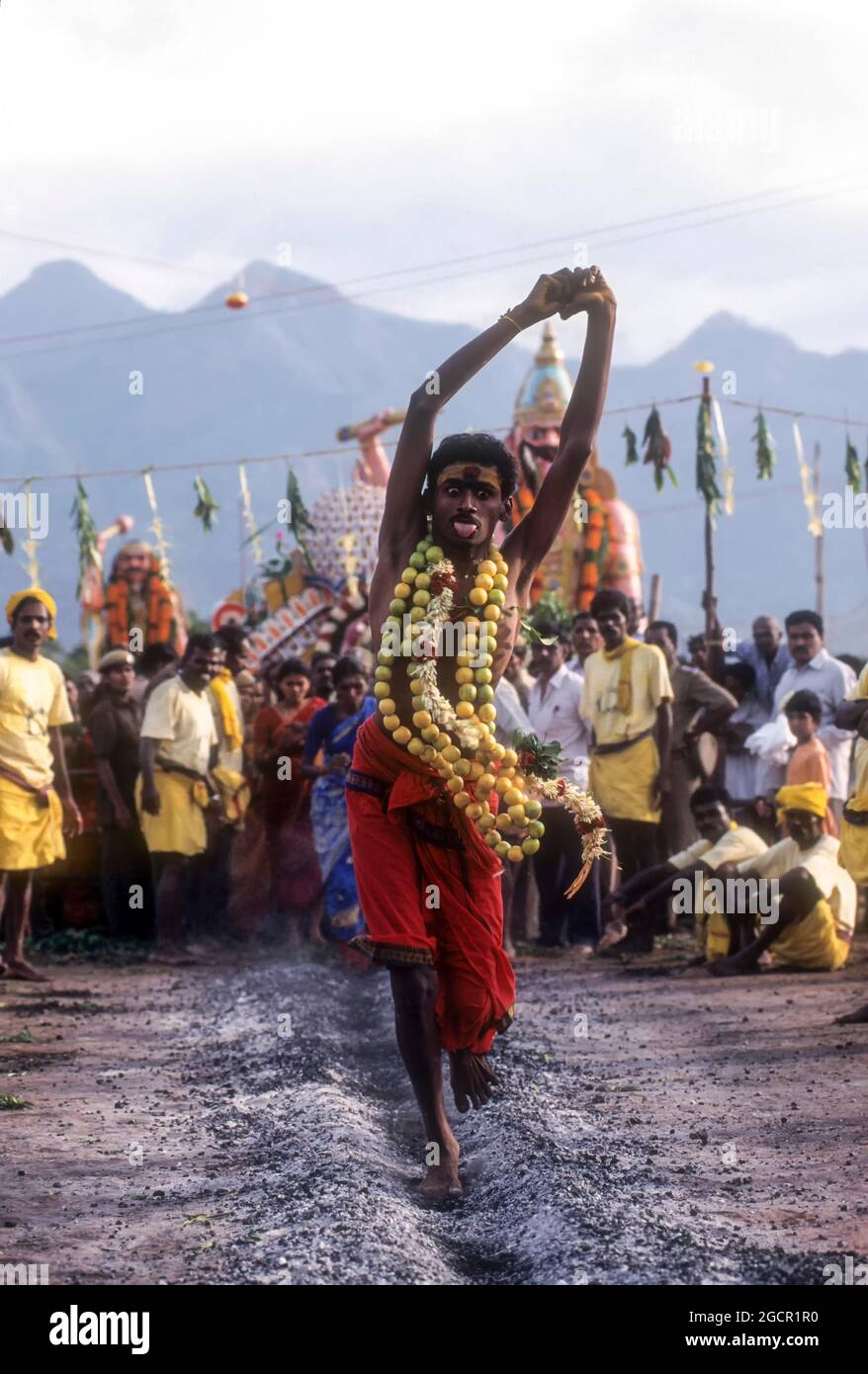 Ein gott besessener Mann, der auf brennender Kohle läuft; Feuerwanderfest am Vana Badra Kali Amman Tempel bei Nellithurai in der Nähe von Mettupalayam, Tamil Nadu, Indien Stockfoto