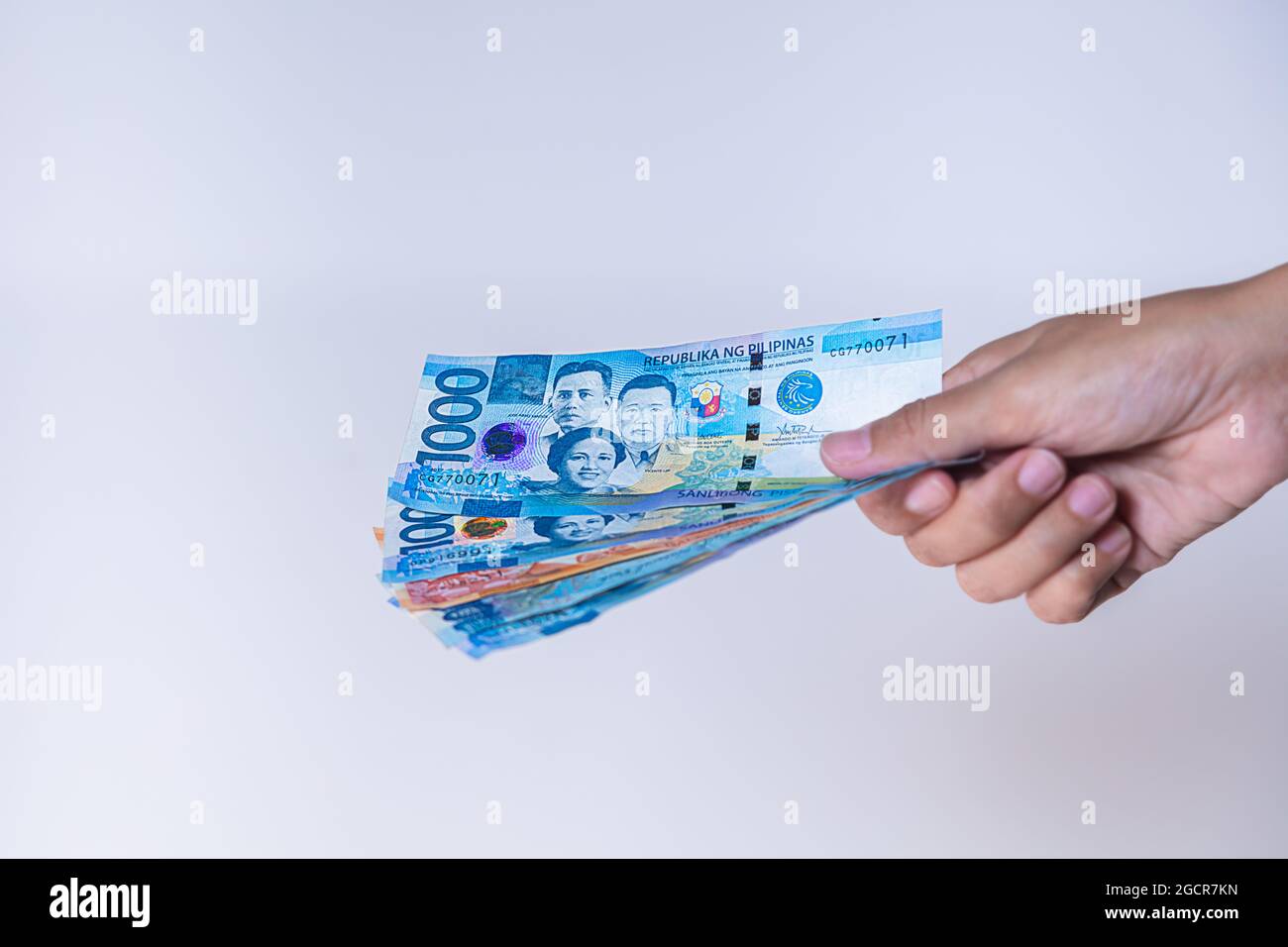 Fan der philippinischen Peso-Banknoten in weiblicher Hand. Die Hände der Frau zeigen philippinisches Pesos-Geld. Mädchen Hände halten Geld von Philippinen. Asiatische Currenc Stockfoto