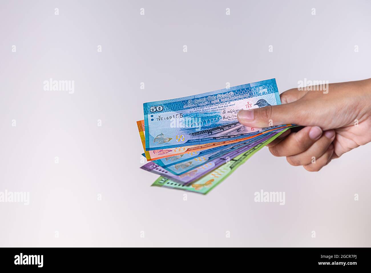 Sri Lanka Rupees Banknoten in weiblicher Hand. Frauenhände zeigen Sri Lanka Ruppie Geld. Mädchen Hände halten Geld von Sri Lanka. Asiatische Währung. Nahaufnahme Stockfoto
