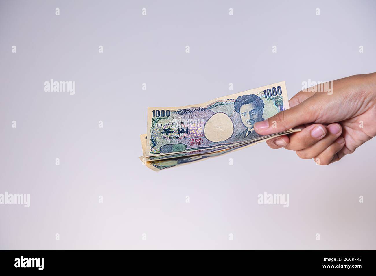 Weibliche Hände zeigen japanischen Yen. Yen ist die Währung Japans. Auf der Vorderseite der Banknoten Hideyo Noguchi, Bakteriologe aus dem 20. Jahrhundert Stockfoto