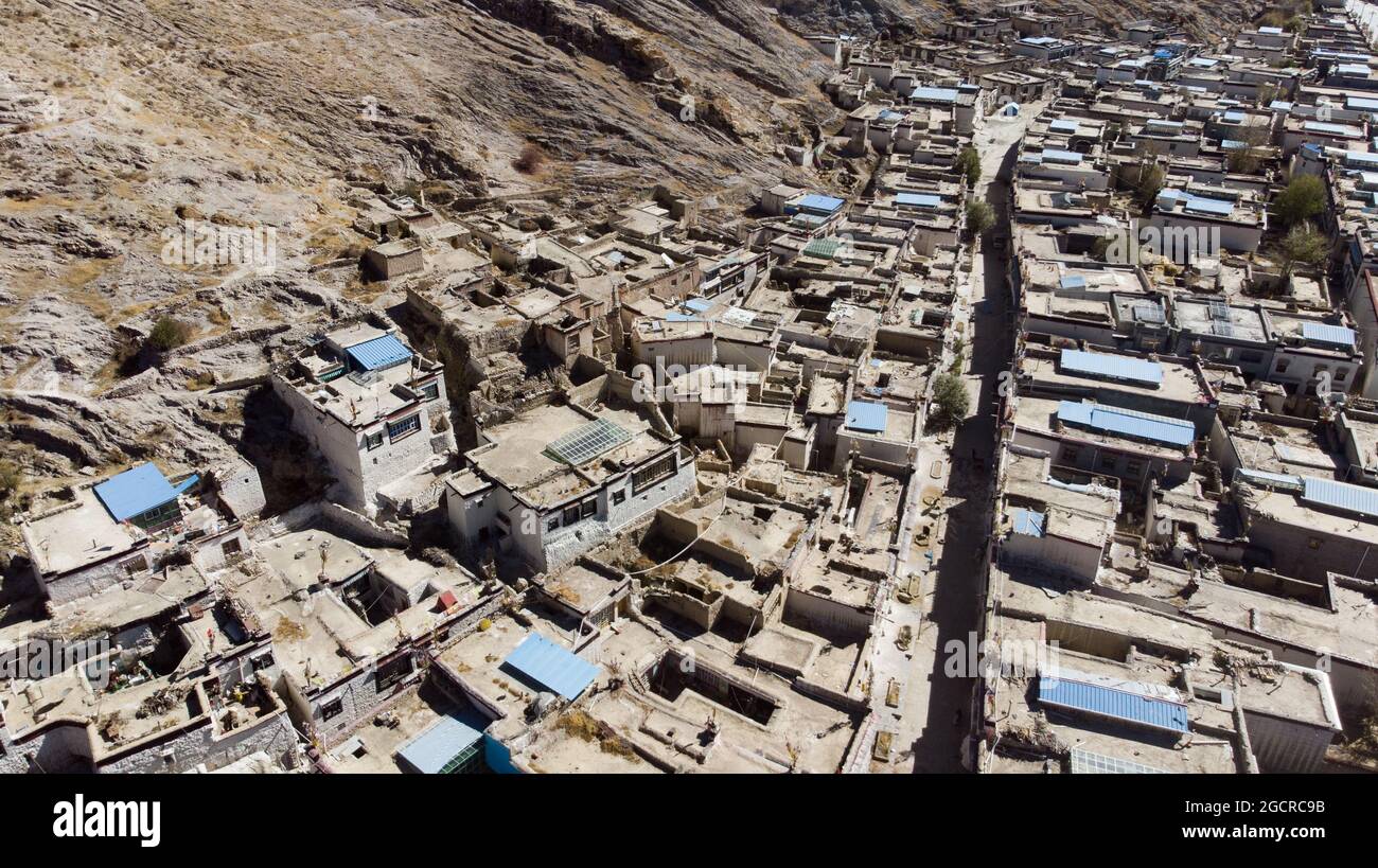 Stadt Xigaze in Tibet vom Himmel aus. Luftaufnahme über ein kleines tibetisches Dorf im Berg des Himalaya. Drohnenblick über das Dach von Shigatse, Stockfoto