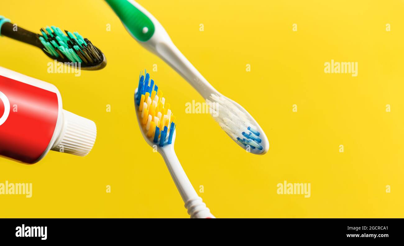 Zahnbürsten und Zahnpastatuben auf gelbem Hintergrund. Speicherplatz kopieren. Selektiver Fokus. Stockfoto