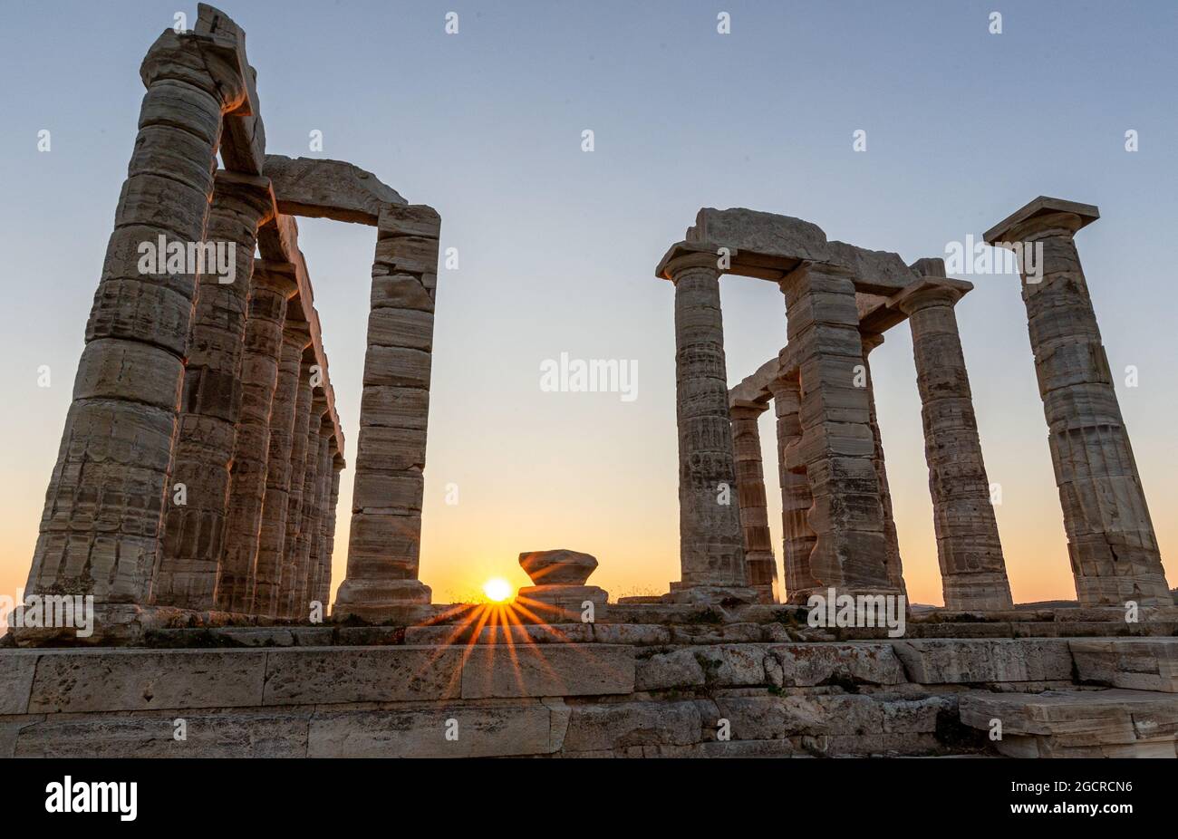 Erstaunlicher farbenprächtiger Sonnenuntergang am Tempel von Poseidon, archäologische Stätte von Sounion, Attika. Kap Sounion, Griechenland. Ein Sonnenuntergang hinter der Zitadelle auf einem Hügel Stockfoto