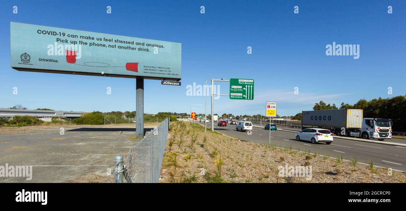 Eine Plakatwand am Straßenrand mit einer COVID-19 Alkoholwarnung auf dem General Holmes Drive, der in der Nähe des Flughafens von Sydney in Mascot, NSW, Australien, nach Süden schaut. Stockfoto