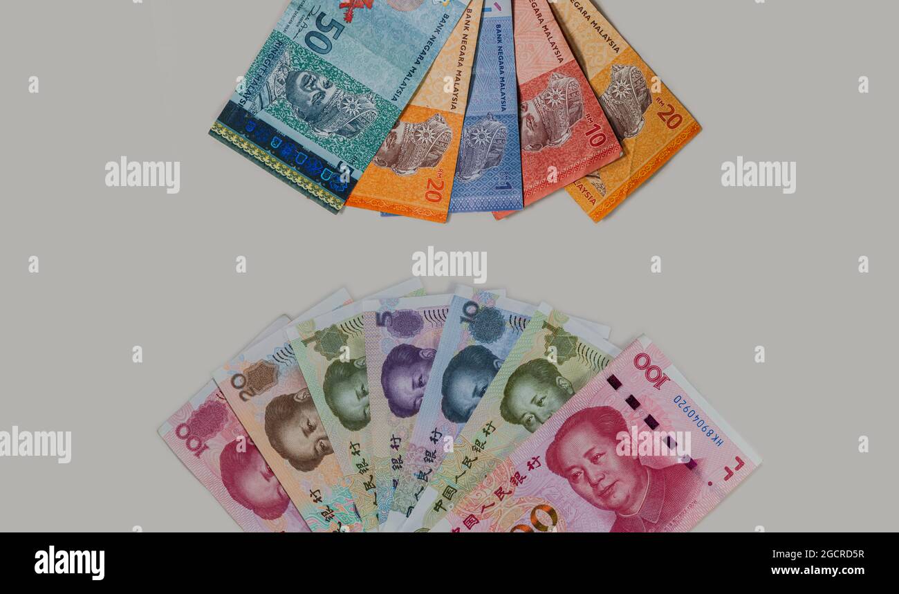 Detaillierte Nahaufnahme der chinesischen und malaysischen Währung auf weißgrauem Hintergrund. Fan von Malaysia Ringgit und China Renminbi Geld. Probennotizen von Stockfoto