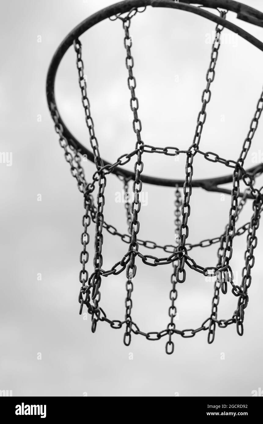 Street Sports, gesundes Lifestyle-Konzept. Basketballkorb gegen den bewölkten Himmel. Monochrom. Stockfoto