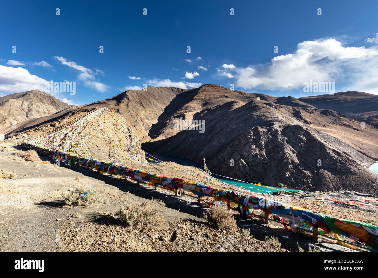 Kong mu Co See auf 5000 Meter über dem Meeresspiegel bei Tibet. Bunte Gebetsfahnen vor dem Wind winken. Türkisfarbenes Wasser im Bergsee. Neigen Stockfoto