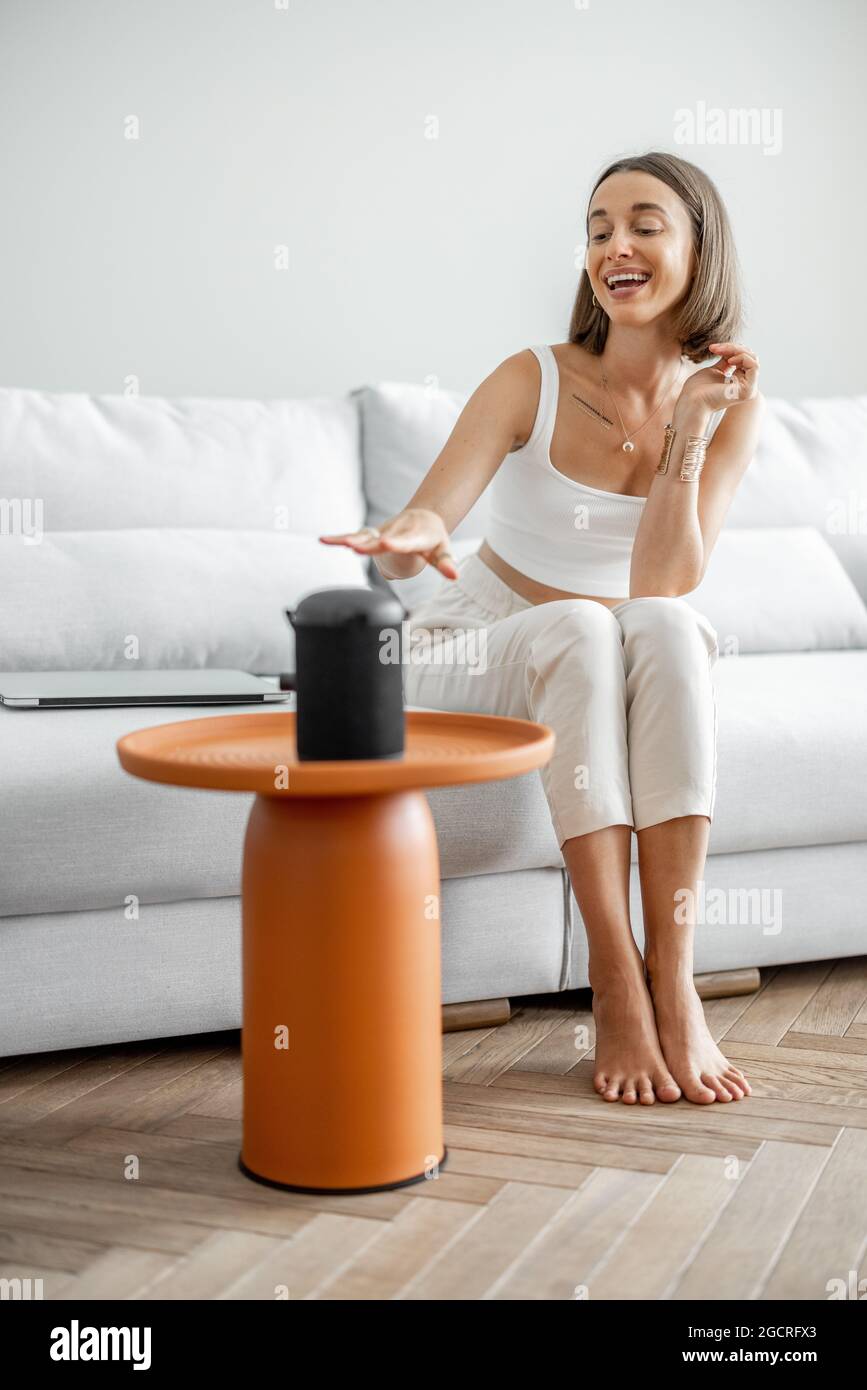 Frau, die Heimgeräte mit Sprachbefehlen verwaltet Stockfoto